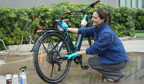 Vrouw die elektrisch fietsframe schoonmaakt