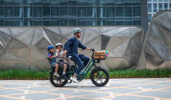 Een man rijdt met twee kinderen op een Fiido T2 e-bike