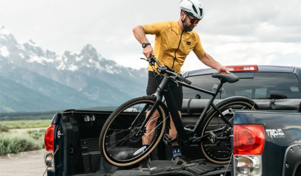 Een man plaatst een Fiido C21 elektrische fiets in de laadbak van een vrachtwagen.