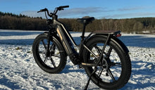 Een Fiido Titan elektrische fiets staat tijdelijk geparkeerd in de sneeuw