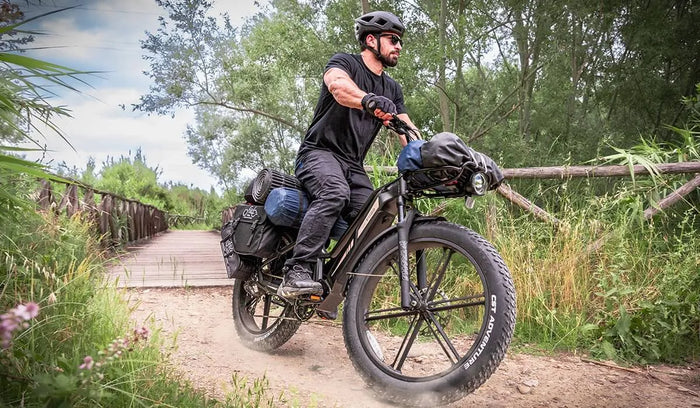 Een man rijdt op een Fiido Titan elektrische fiets door de bergen.