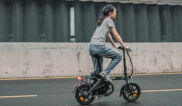 Mujer montando una bicicleta eléctrica Fiido D3 Pro a través del agua.