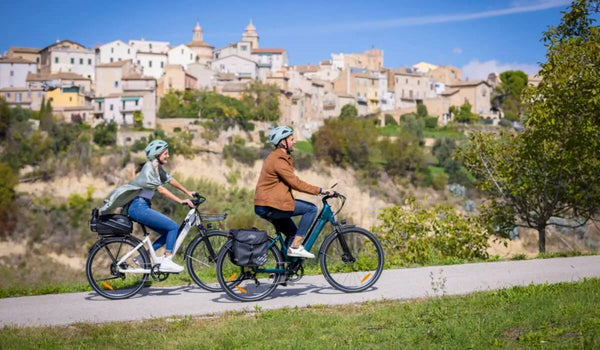 Een man en een vrouw fietsen heuvelopwaarts op Fiido C11 elektrische fietsen.