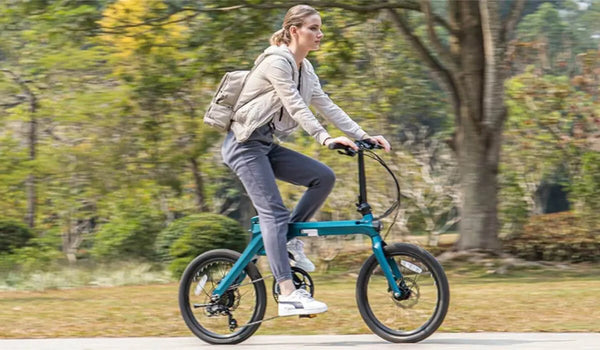 Een vrouw rijdt op een Fiido X elektrische fiets door een weelderig park.