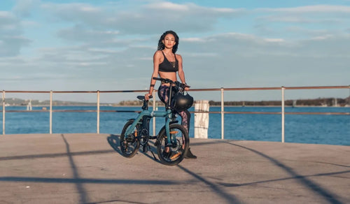 Vrouw met Fiido D11 op een promenade langs het meer, waarbij haar stijl wordt benadrukt.