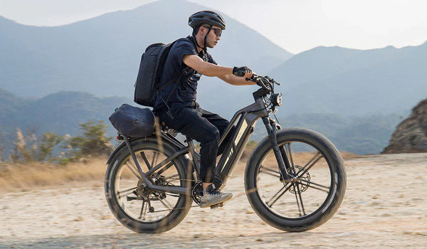 Een man rijdt off-road op een Fiido Titan elektrische fiets