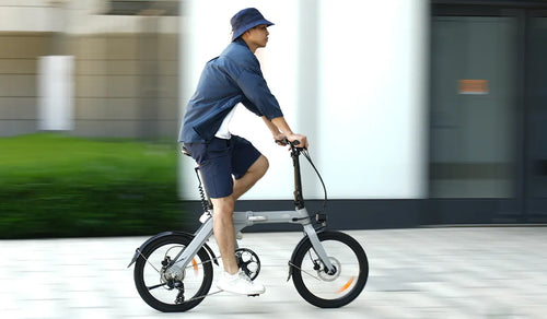 Een man op een Fiido D11 elektrische fiets op een stadsstraat.