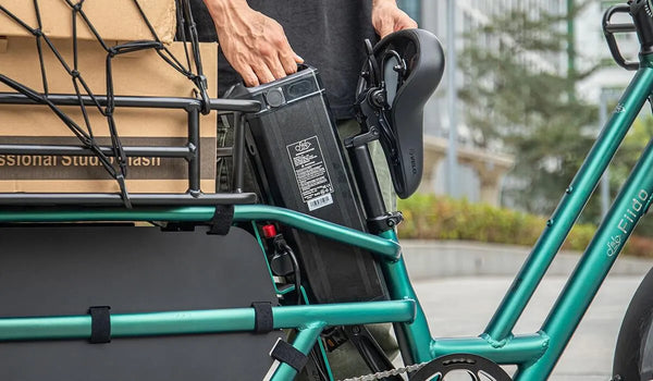 Een man maakt zich klaar om de batterij van een Fiido T2 elektrische fiets te onderhouden.