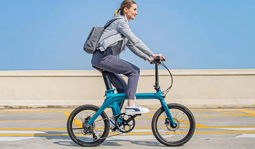 Vrouw rijdt op een Fiido X elektrische fiets op straat.