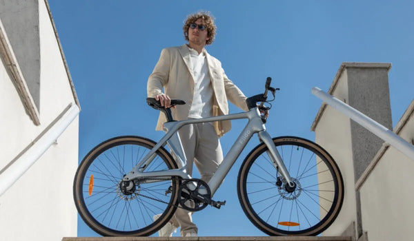 Een man fietst op een Fiido Air elektrische fiets met carbon frame door de stad.