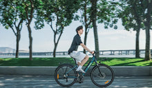 Een man rijdt op een lichte Fiido elektrische stadsfiets door een stadsstraat.