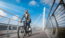 Een man rijdt op een Fiido C21 elektrische fiets met trapondersteuning op een fietspad.