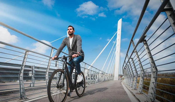 Een man rijdt op een Fiido C21 elektrische fiets met trapondersteuning op een fietspad.