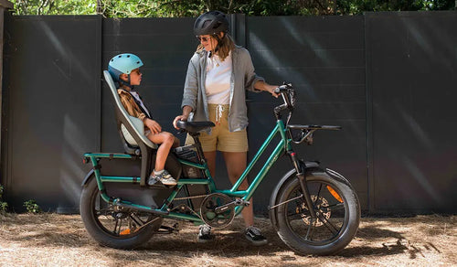 Een vrouw gebruikt een Fiido T2 elektrische fiets met een kinderzitje achterop.