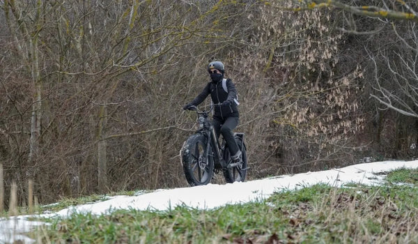 Een vrouw rijdt op een Fiido Titan elektrische fiets door de sneeuw.