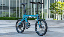 De Fiido X elektrische fiets geparkeerd in een modern stadslandschap.