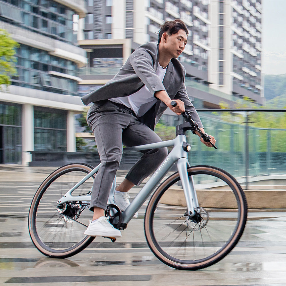 Man rijden koolstofvezel Fiido Air elektrische fiets op natte weg