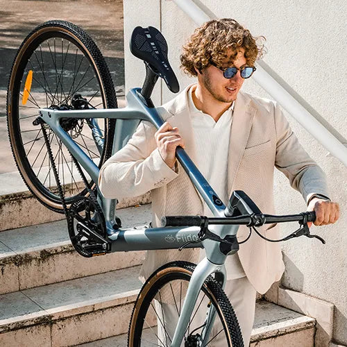 Man tilt een Fiido carbon e-bike van de trap